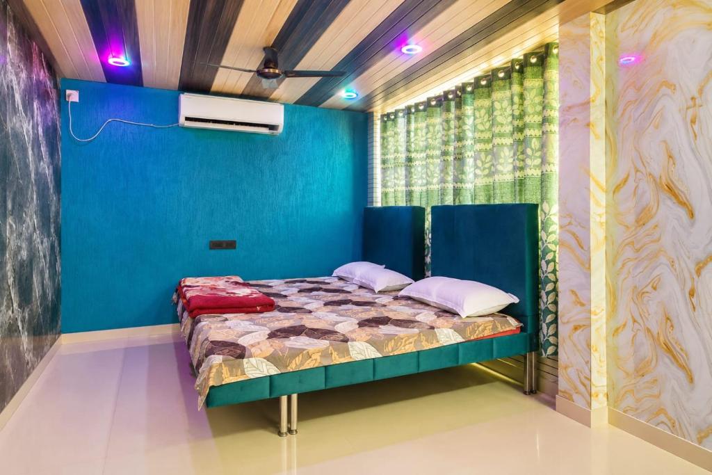 a bed in a room with a blue wall at Hotel Celebration in Chaupāran