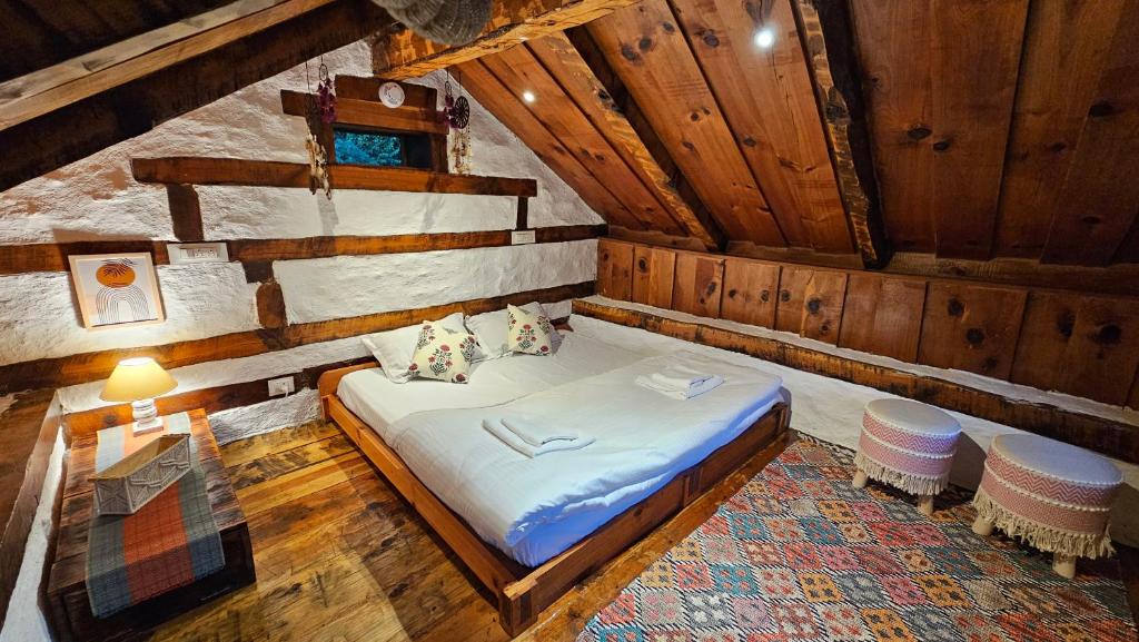 ein Schlafzimmer mit einem Bett in einer Holzhütte in der Unterkunft Parvatis Lap Villa & Hostel in Kasol