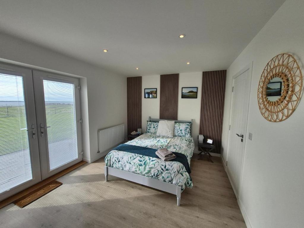 a bedroom with a bed and a large window at Sea Breeze - Sea Scape View in Keiss