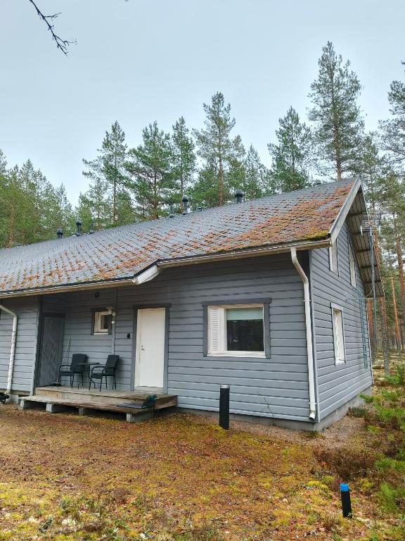 a small house with a porch and two chairs at Mökki Jyrkinkuja in Loimaa
