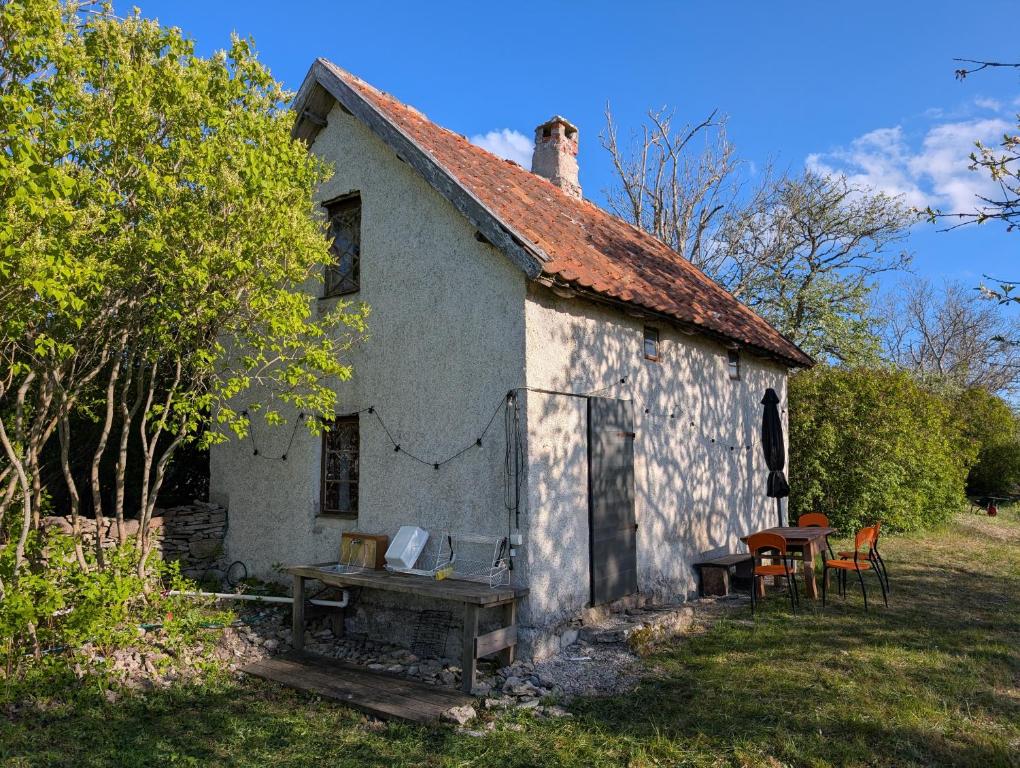 an old white house with a table and chairs at Lillstugan på Lansa in Aurgrund