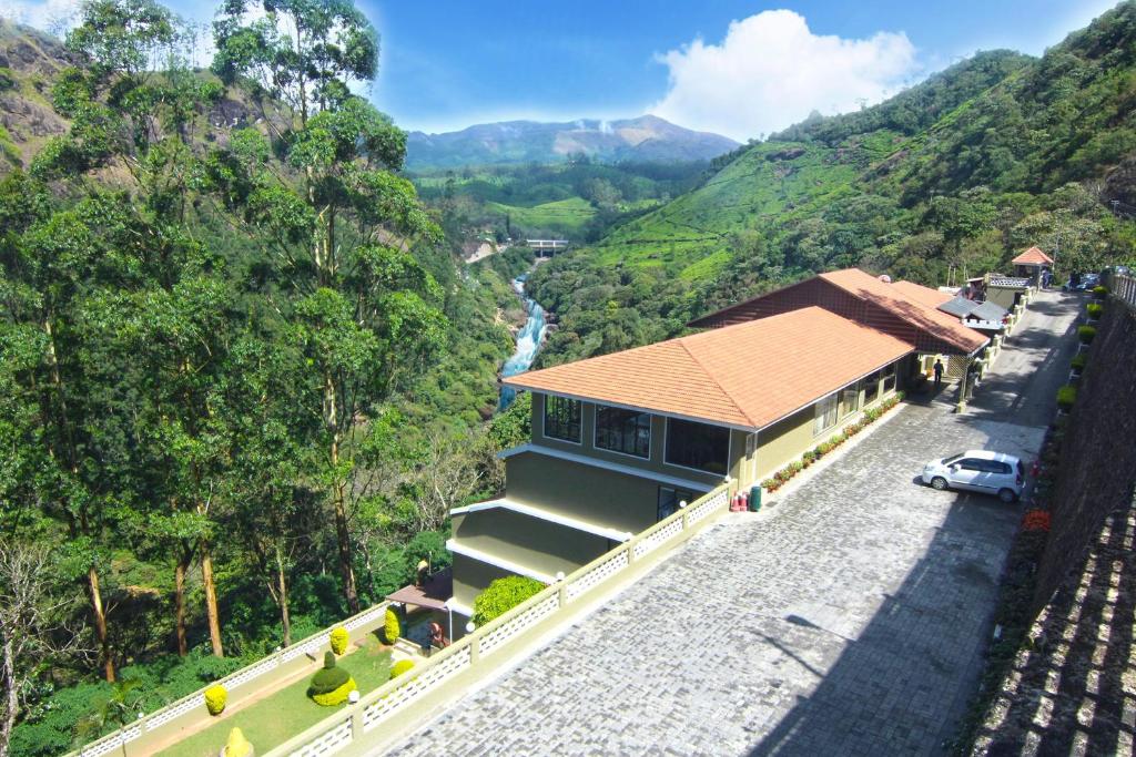 een huis aan de kant van een weg naast een berg bij Abad Copper Castle Resort in Munnar