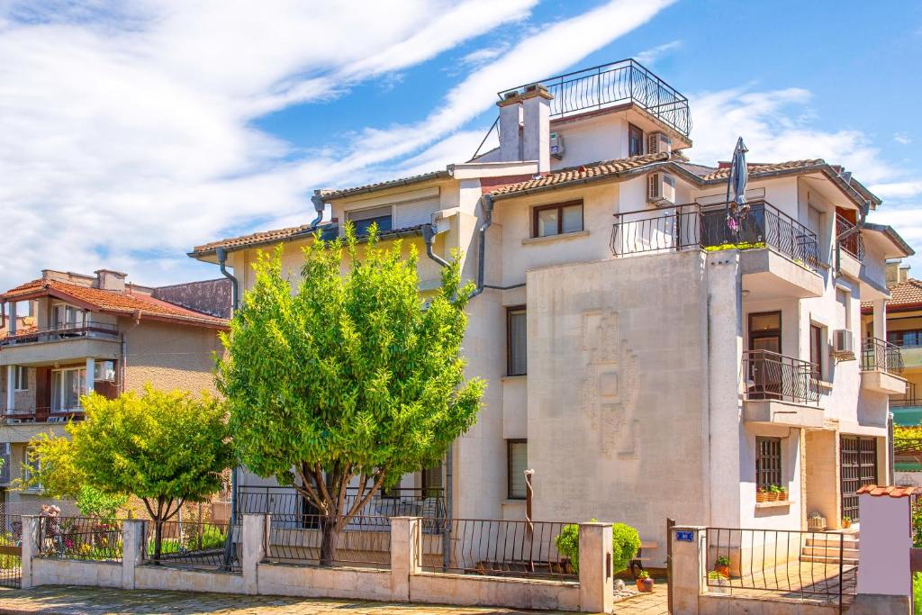 an apartment building with a tree in front of it at Valchevi Apartments in Chernomorets