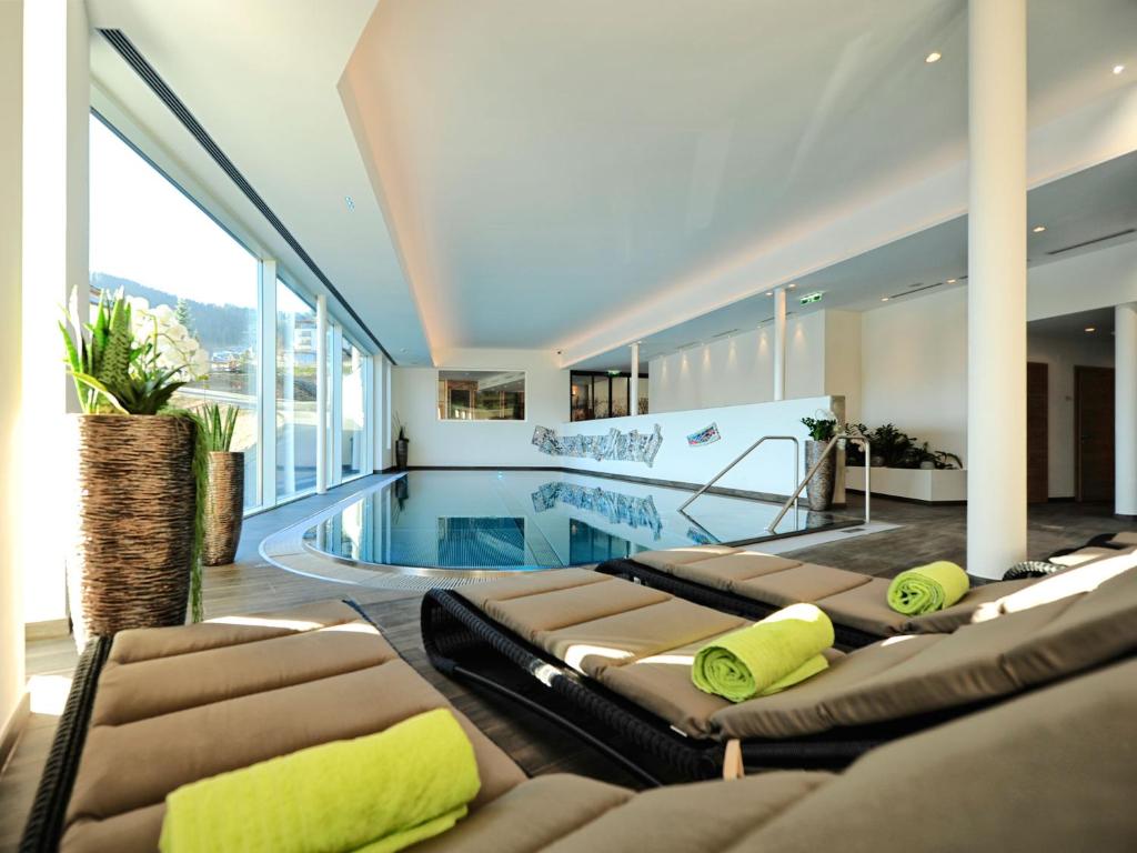 una camera con piscina e diversi letti di Hotel Röck Garni a Fiss