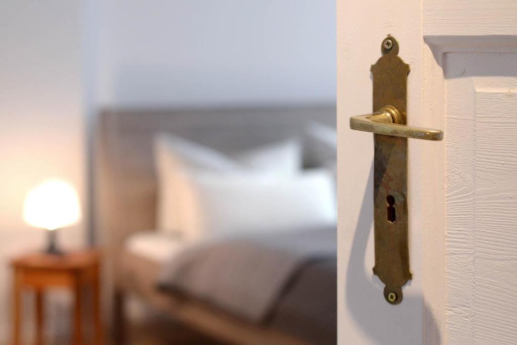 a doorhandle to a bedroom with a bed at Sleep Like Home Winsviertel in Berlin