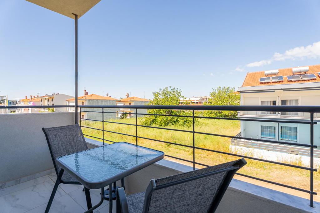 a balcony with a table and two chairs at SithoniaRS Sea Nomad Luxury Maisonette in Nikiti