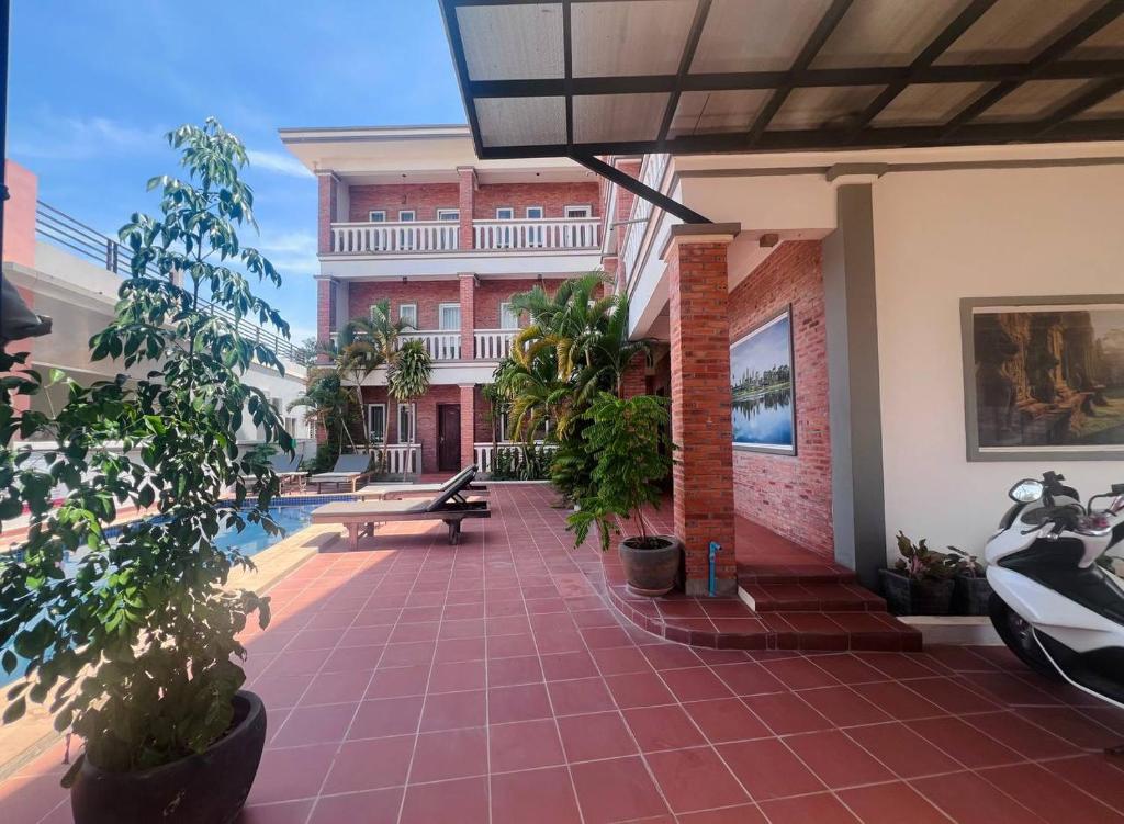 a courtyard of a building with a bench and plants at Monterey Angkor Boutique in Phum Pobos