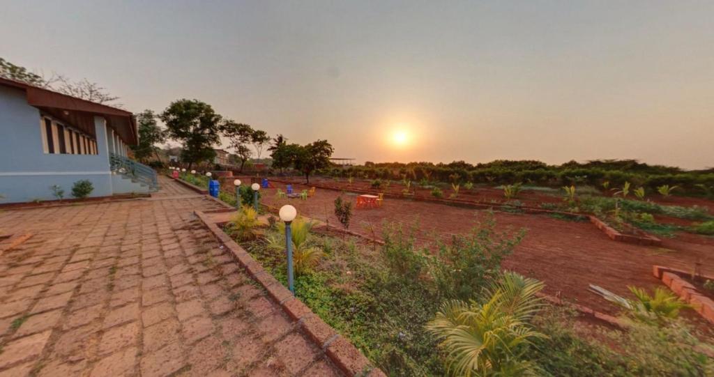 a sunset over a garden with a brick road at Beach and Hills Resort Diveager in Kārle