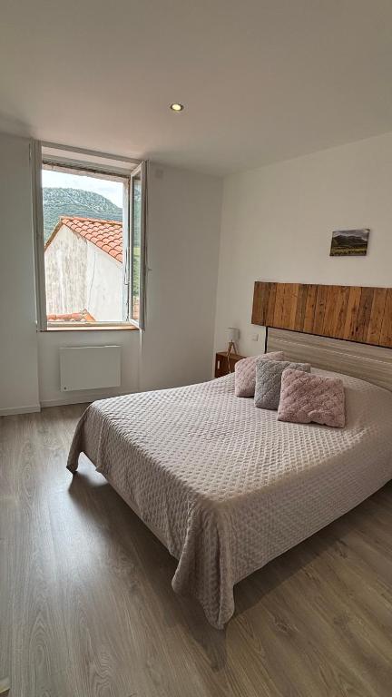 a bedroom with a large bed and a window at La Tomette - Gîte Eco Responsable - Le charme de l'authentique Climatisé in Maury