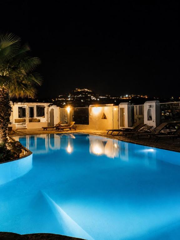 a large swimming pool at night with blue lights at Cozy Summer House in Mikonos
