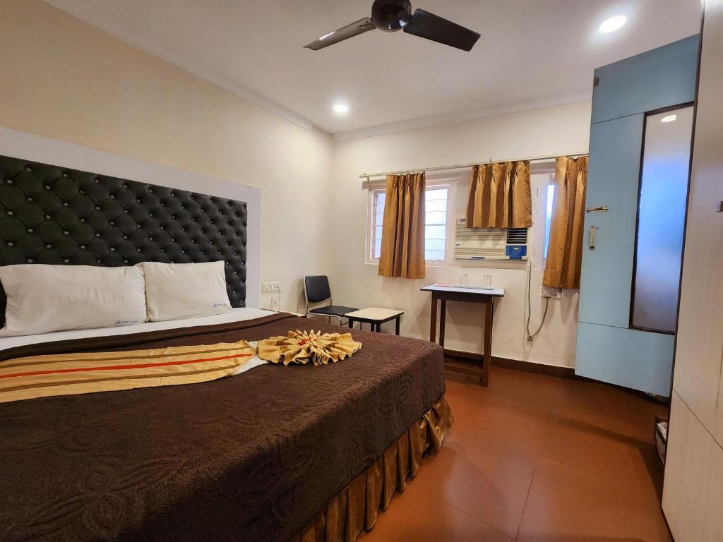 a bedroom with a large bed and a bathroom at Hotel Al Sana in Kolkata