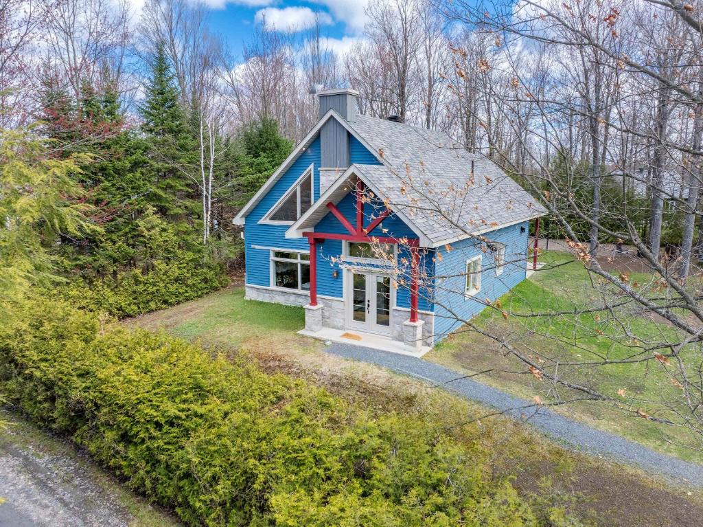 a blue house in the middle of a yard at Spa Relaxation & Adventure - Lapointe du Lac in Saint-Gérard