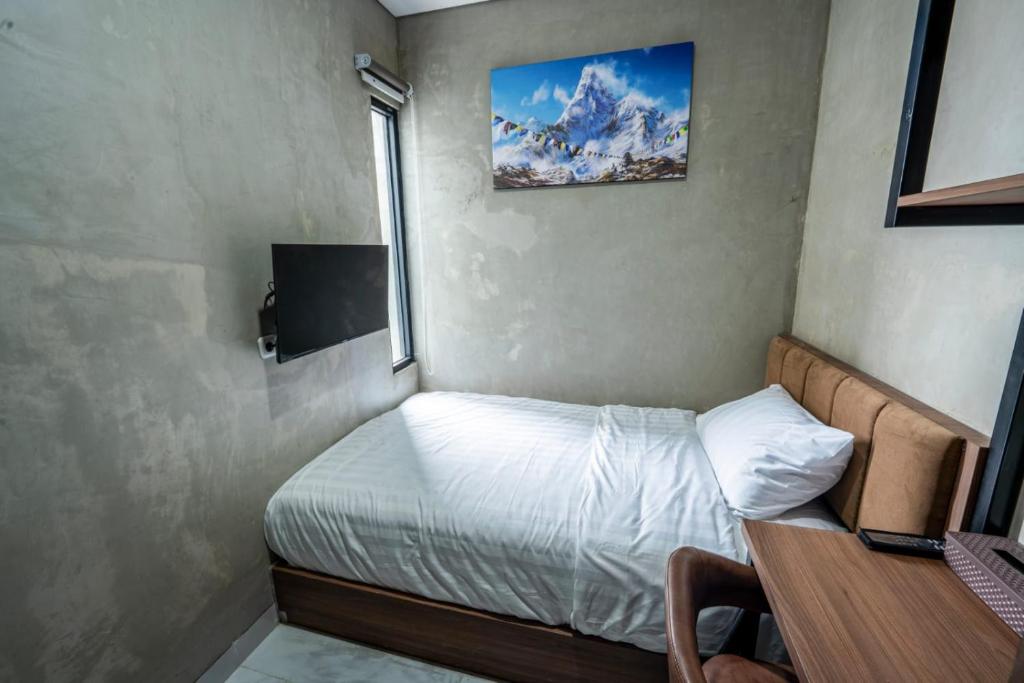a small bedroom with a bed and a window at Trifena Residence in Kalibanteng-lor