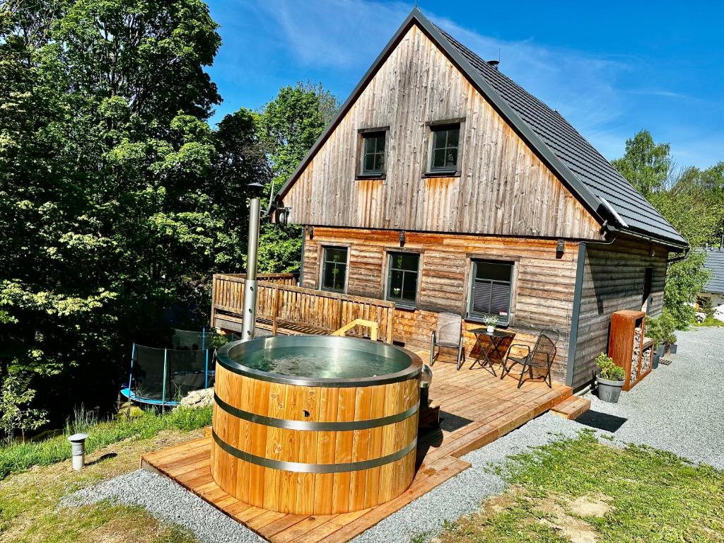 a large wooden house with a hot tub on a deck at Chalet Olešnice in Olešnice v Orlických horách
