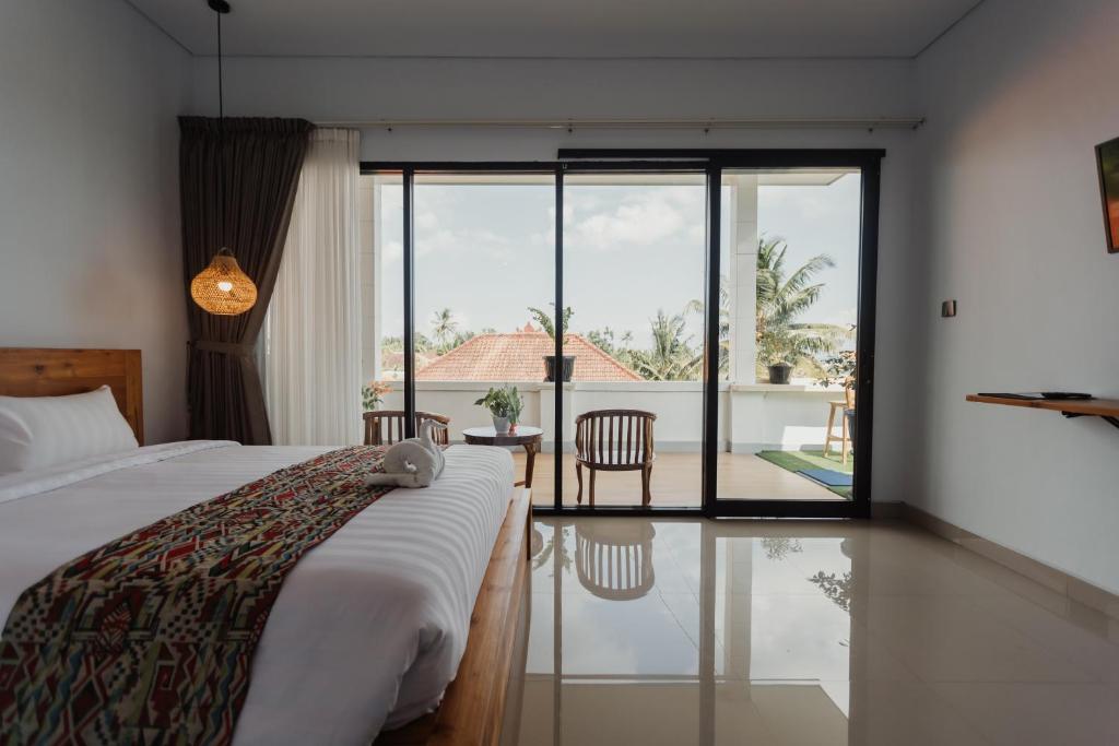 a bedroom with a bed and a view of a patio at Dana's Kelating Guest House, Close to Kelating Beach in Tabanan