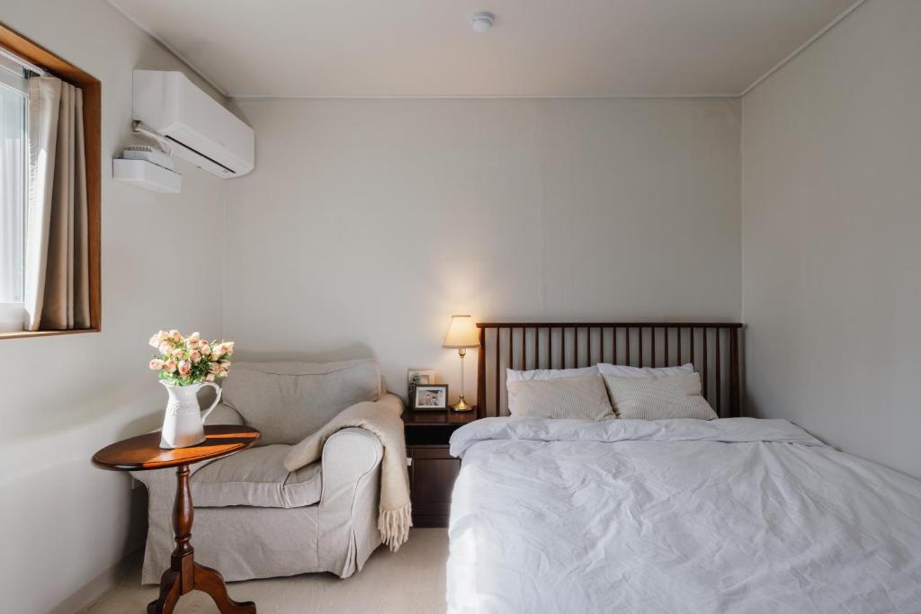 a bedroom with a bed and a chair and a table at 포켓서울 문래점 in Seoul