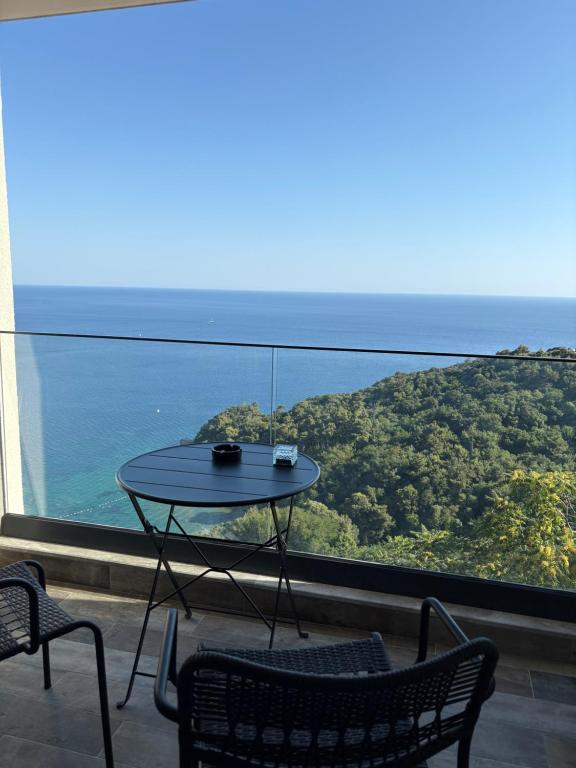a table on a balcony with a view of the ocean at Panoramic Sea View in Budva
