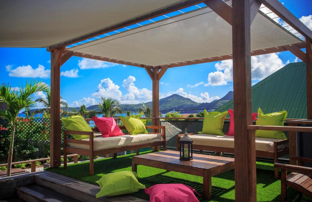 un patio con cenador y almohadas coloridas en Villa Eugénie, en Gustavia