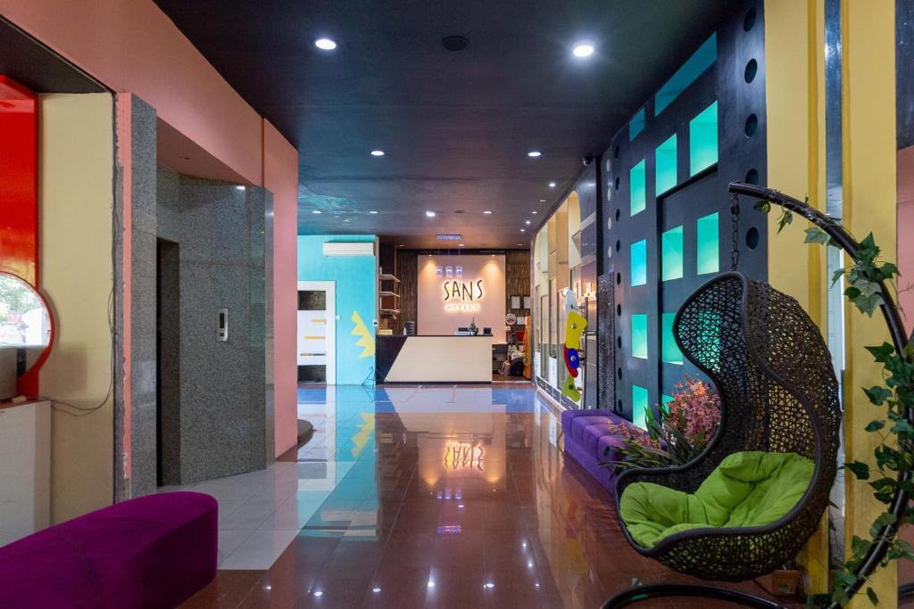 a hallway of a store with purple and green chairs at Sans Hotel International Surabaya in Gubeng