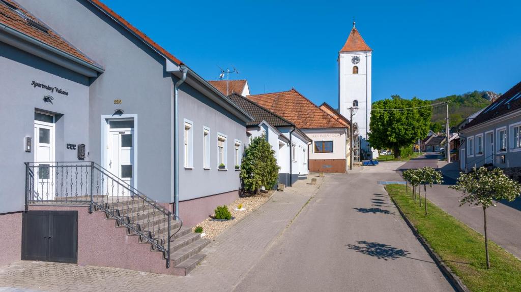 an empty street in a town with a clock tower at Apartmány Vulcano in Perná