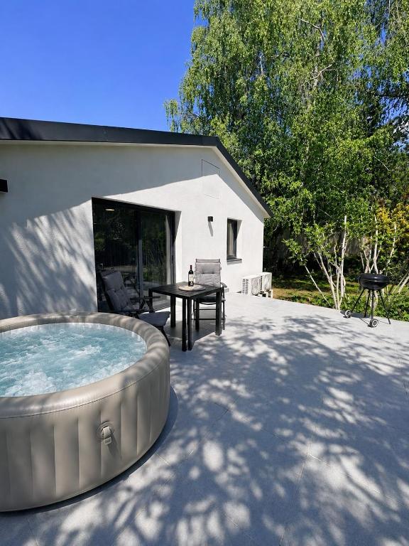 a backyard with a hot tub and a table at Peaceful Garden Hideaway in Gárdony