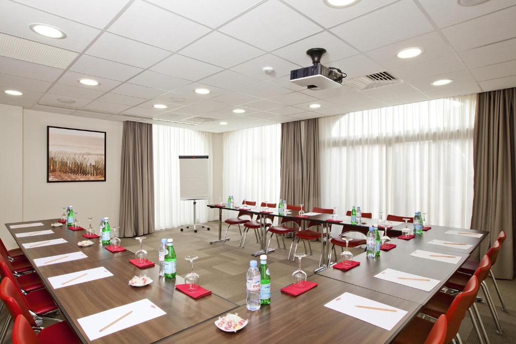a conference room with a long table and red chairs at Residhome Arcachon Plazza in Arcachon