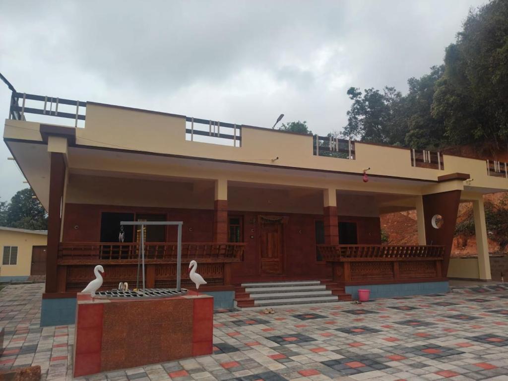 a building with two swans in front of it at Sri Skandaa in Sringeri