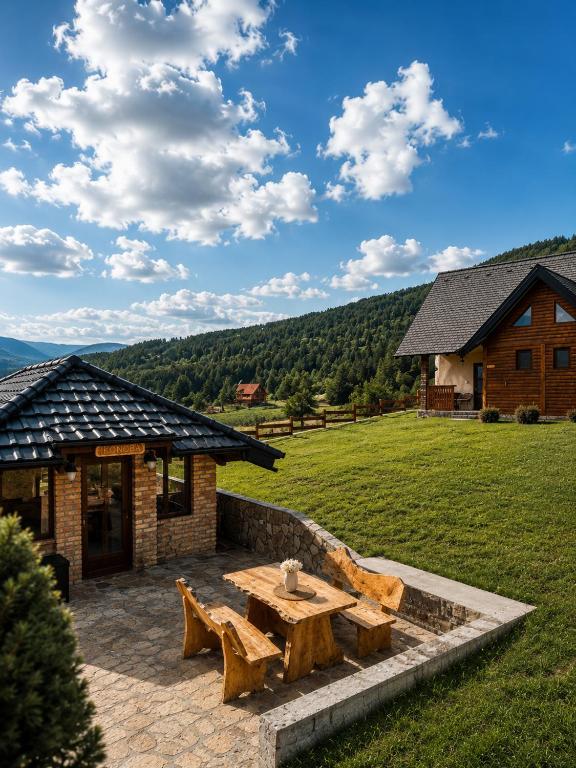 a patio with a wooden table and a building at Iskrin breg in Ribnica