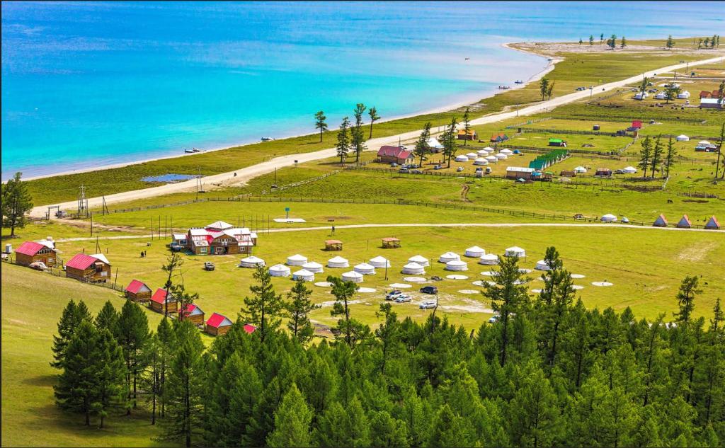 a group of tents on a field next to a beach at Blue Pearl - Khovsgol Lake in Khyaktil