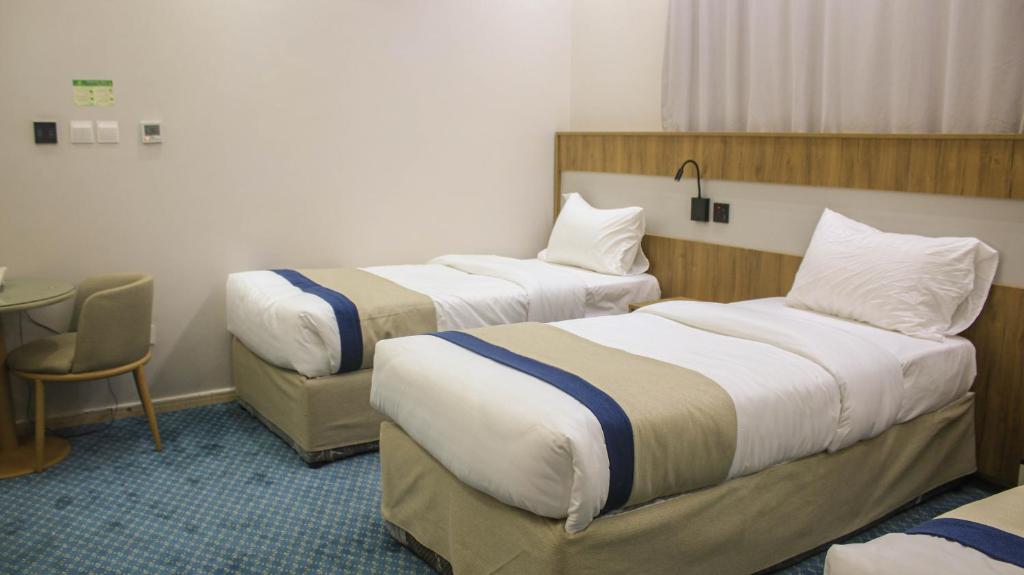 a hotel room with two beds and a table at فندق برج جزيرة العرب in Medina