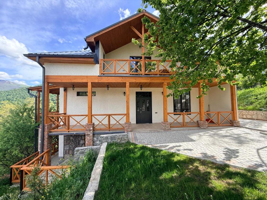 a house on a hill with a porch at Mountain Symphony Cottage Dilijan in Dilijan