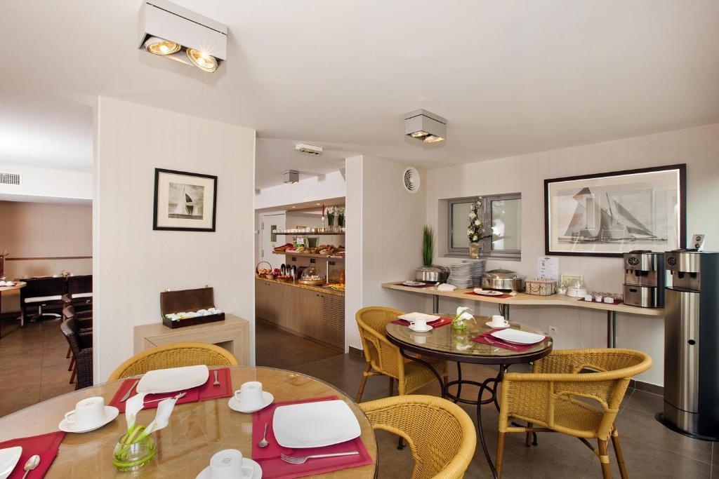 a living room with a table and chairs and a kitchen at Residhome Arcachon Plazza in Arcachon