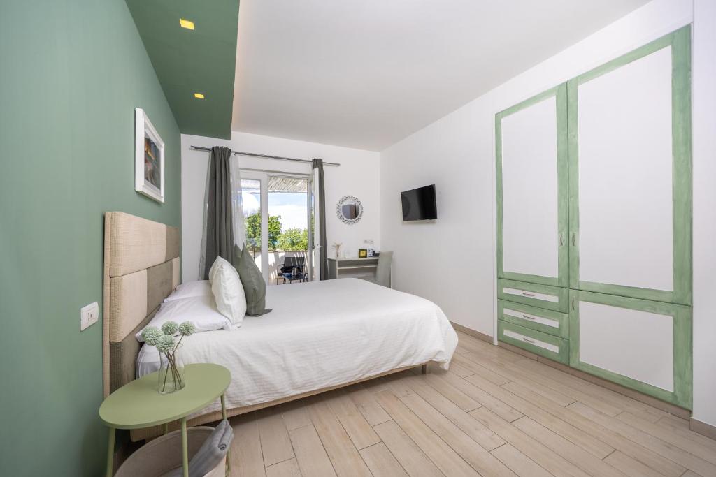 a bedroom with a white bed and a green wall at Relais Villa Anna in Anacapri