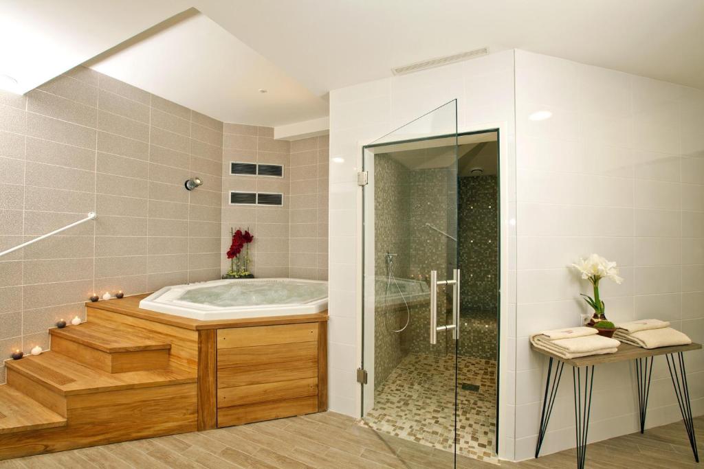 a bathroom with a tub and a glass shower at Residhome Arcachon Plazza in Arcachon