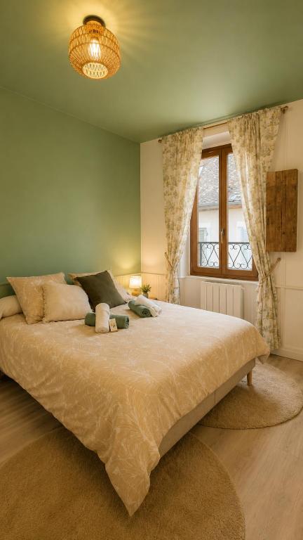 a bedroom with a large bed and a window at Le Refuge de Mandrin, Elegance et tranquilité in Saint-Genix-sur-Guiers
