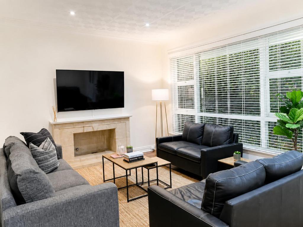 a living room with couches and a flat screen tv at Light-Filled Modern Home 3BR Pet-Friendly 5km-CBD in Perth