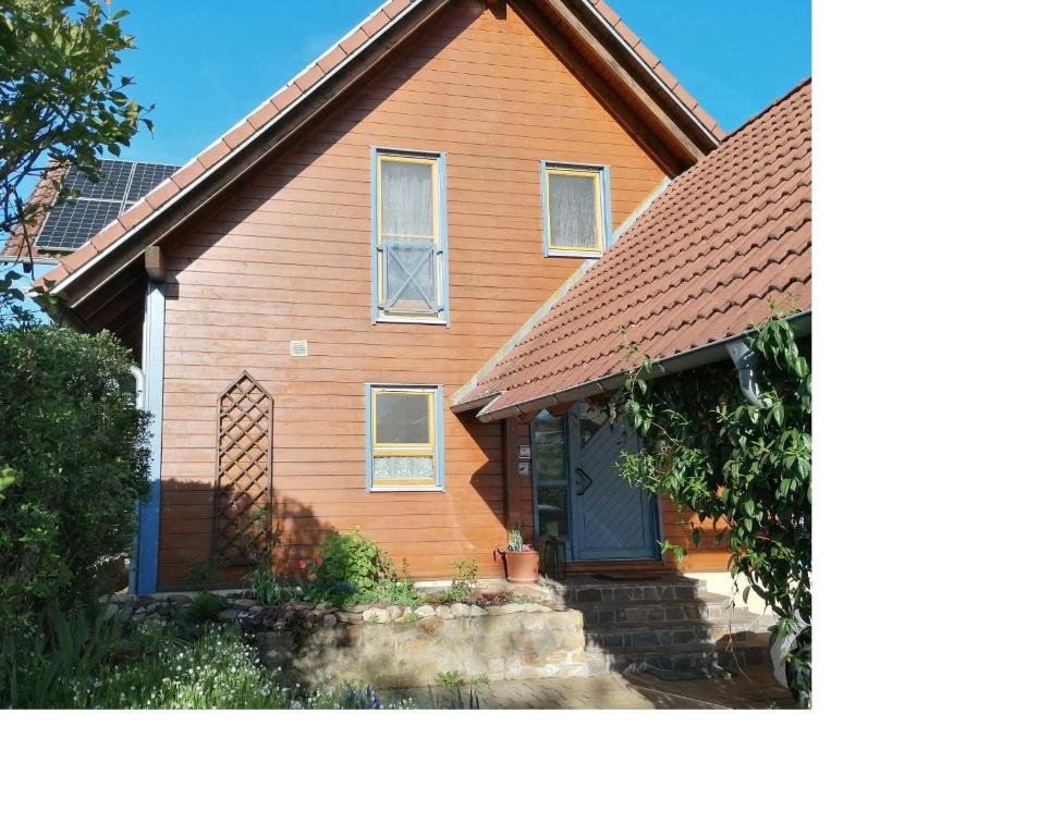 a brown house with a blue door at Ferienhaus Nebenan Plus in Ebern