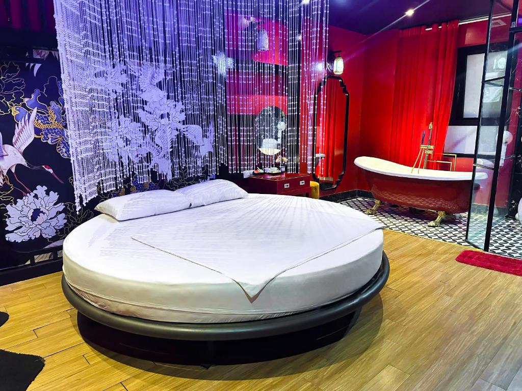 a bedroom with a bed and a tub in a room at Zenshunga Hotel Yên Hoà- Hà Nội in Hanoi