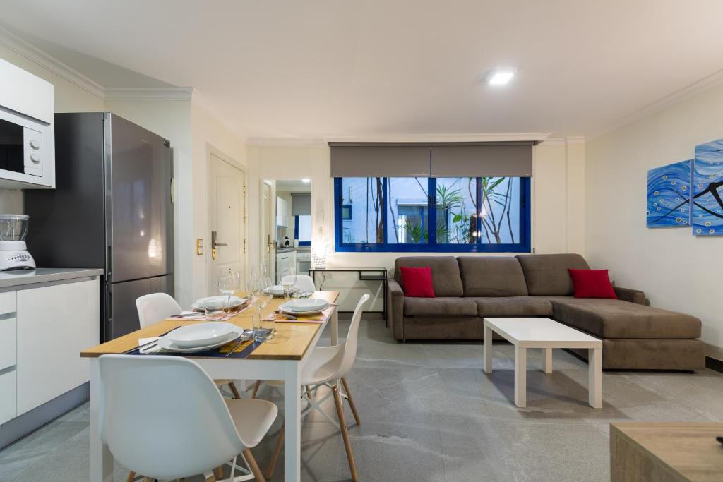 a kitchen and living room with a table and a couch at Suites Garden Apartamento 15 in Las Palmas de Gran Canaria