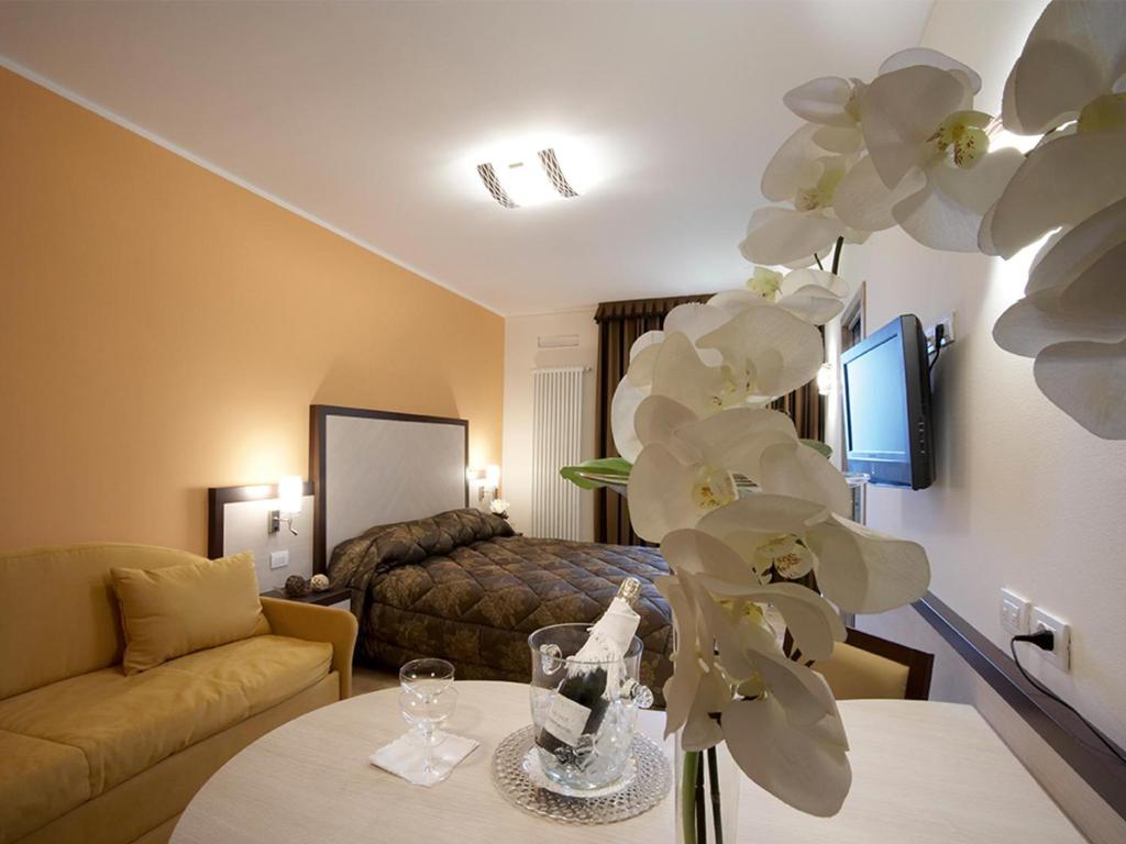 ArsieroにあるGiorgio e Flora Ristorante e Locandaのベッドと花のテーブルが備わるホテルルームです。