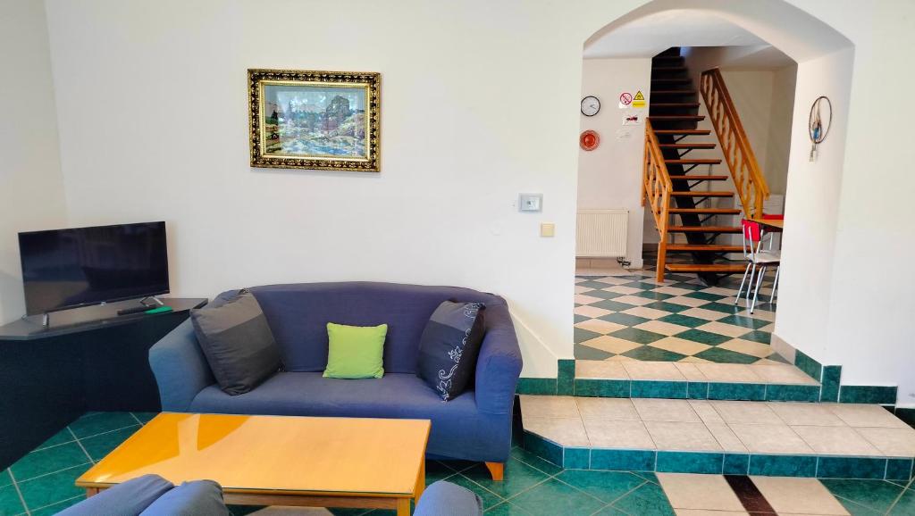 a living room with a blue couch and a table at Andels apartments Vila 3 in Rynholec