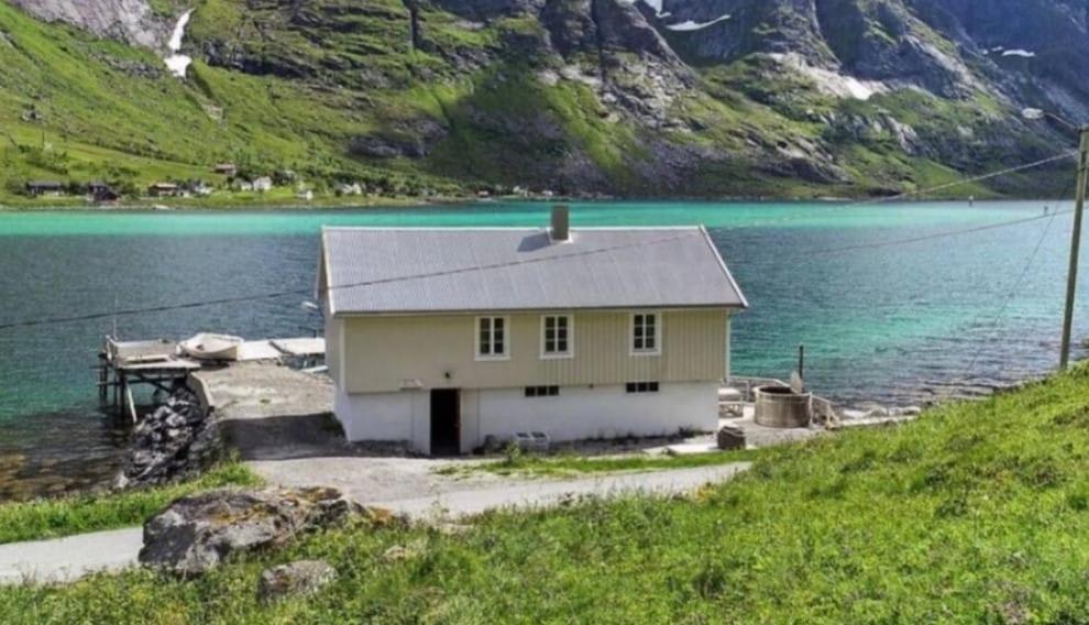 a small house on the shore of a lake at Skjellfjord cabin in Skjelfjord