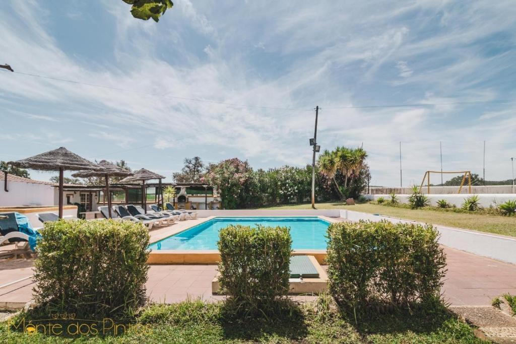 a swimming pool in a resort with lounge chairs at Monte dos Pintos in Arronches