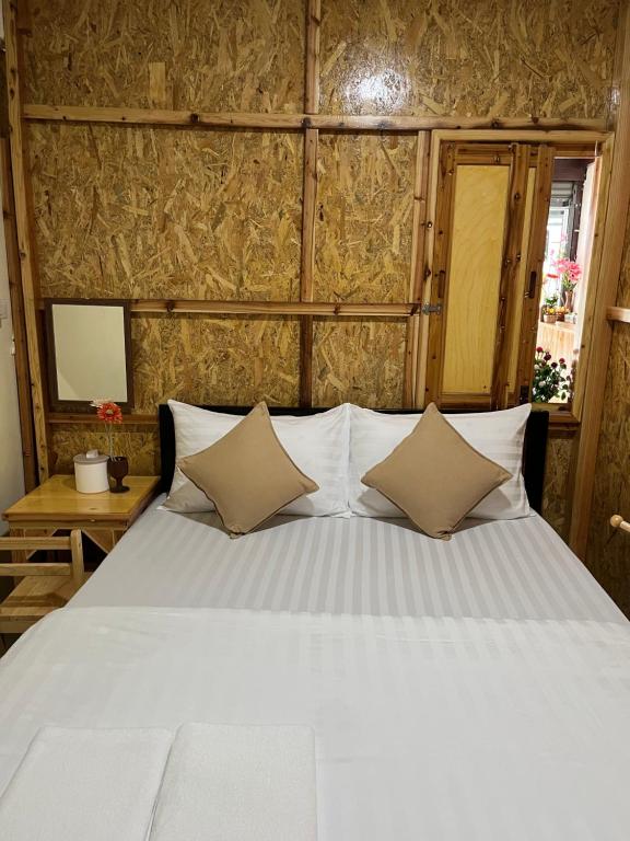 a bedroom with a large bed with white pillows at SDD HoSTEL in Thung Si Kan