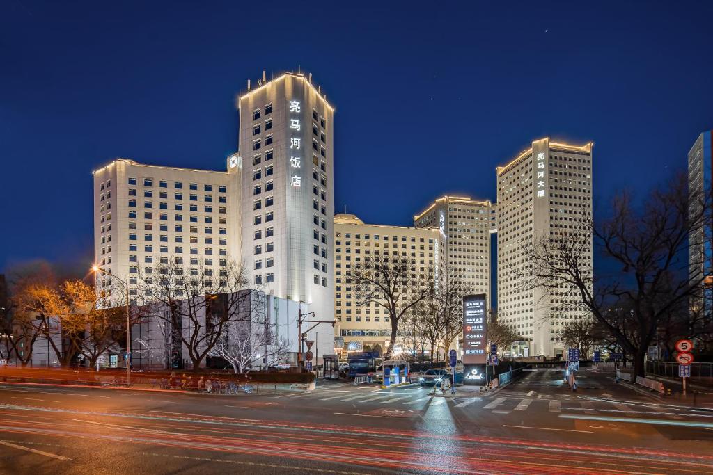 a large white building with many windows at night at Beijing Landmark Hotel in Beijing