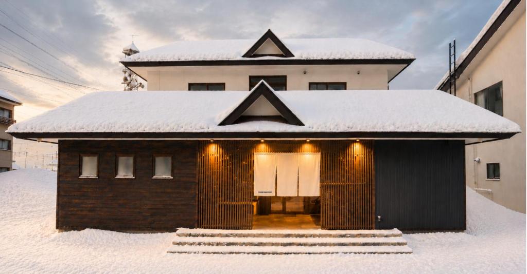 a small building with snow on the roof at nozawasnow in Nozawa Onsen