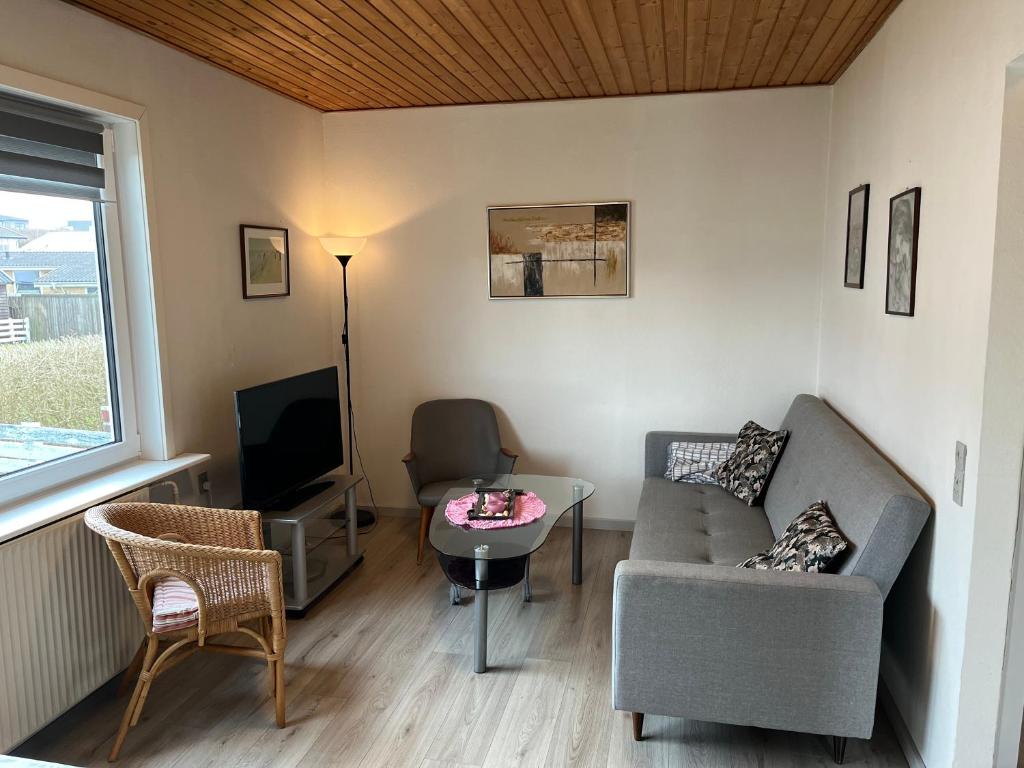 a living room with a couch and a tv at Cozy Apartment in Hirtshals in Hirtshals