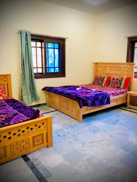 two beds in a room with purple sheets at Rayn Basayra Kashmir in Bāta