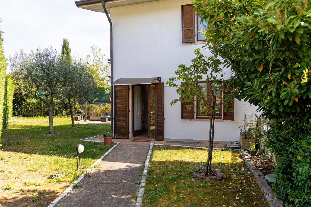 a white house with a tree in the yard at Bc Garda House in Peschiera del Garda