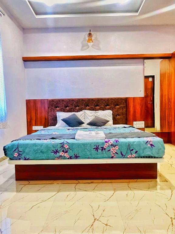 a bedroom with a large bed with a wooden headboard at Geetanjali hotel and resort in Udaipur